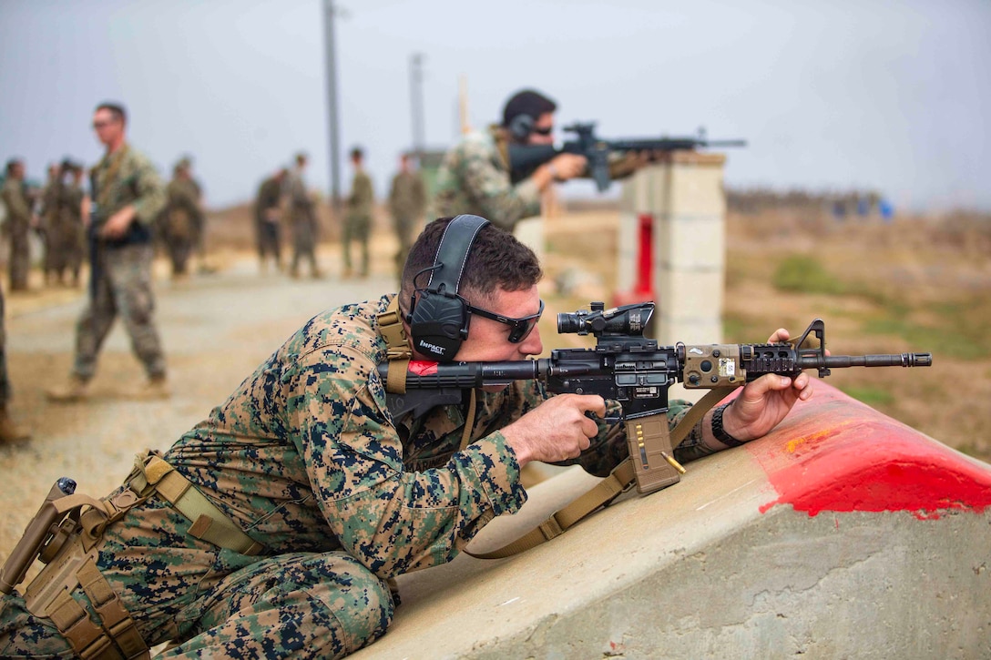 A Marine fires a rifle at a target.