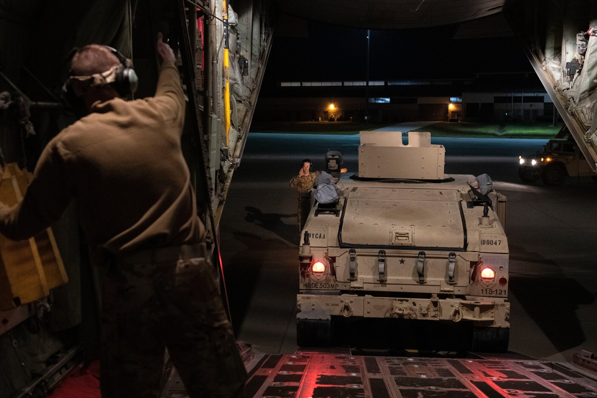 Man guiding truck onto plane