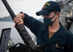 Gunner's Mate Seaman Brady Kamper, from Waterford, Pa., attaches a barrel to a .50-caliber machine gun aboard the Arleigh Burke-class guided-missile destroyer USS Curtis Wilbur (DDG 54).