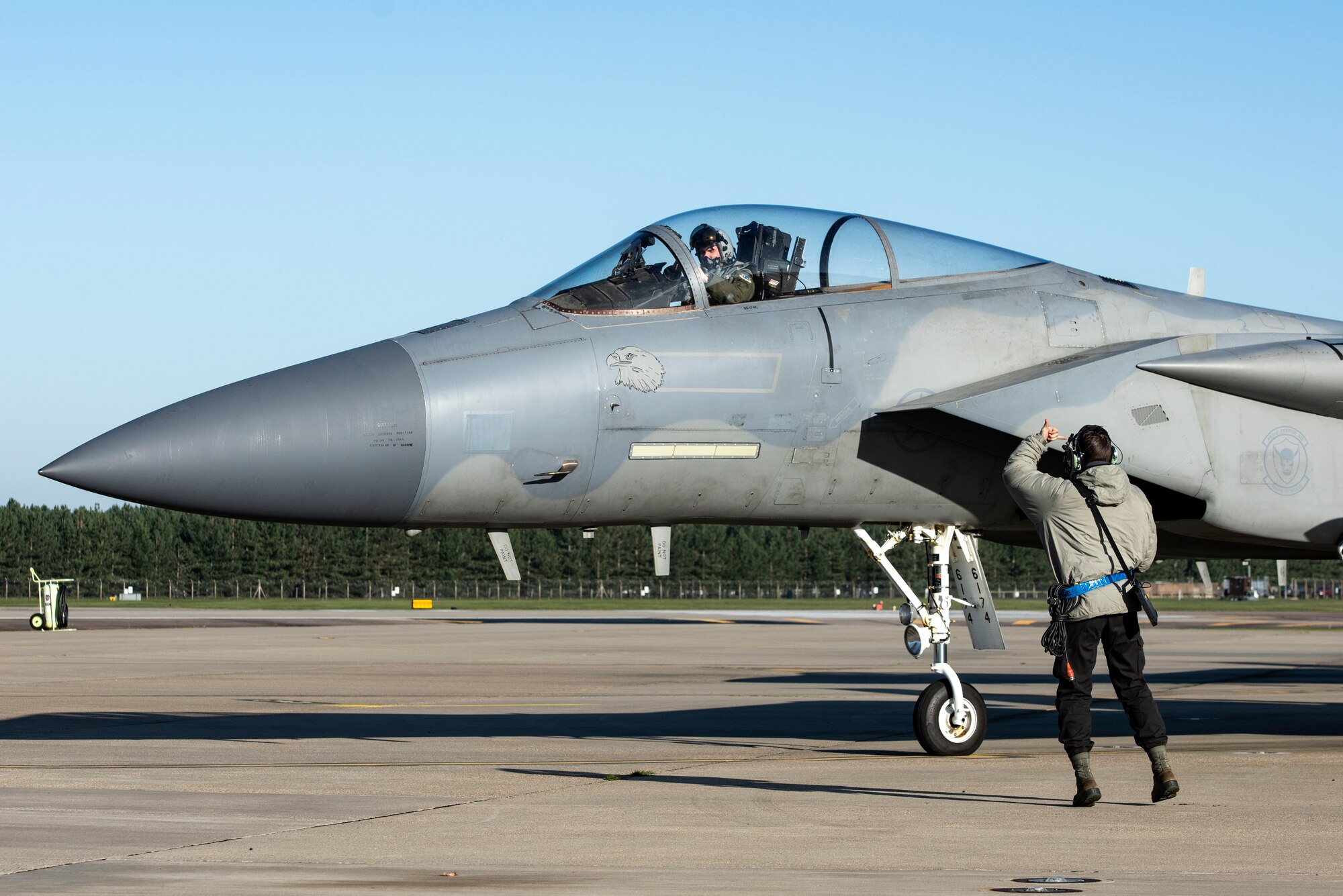 U.S. Air Force Airman 1st Class Tyler Thomas, 492nd Aircraft Maintenance Squadron crew chief, clears an F-15C Eagle for take off in support of exercise Crimson Warrior, at Royal Air Force Lakenheath, England, Nov. 4, 2020. Multi-domain integration exercises like Crimson Warrior strengthen NATO interoperability and test high-end capabilities in a contested, degraded, and operationally limited environment. (U.S. Air Force photo by Airman 1st Class Jessi Monte)