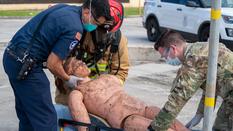 Members of the 36th Medical Group and 36th Civil Engineering Squadron lay a mannequin on a stretcher during Exercise Sling Stone 21-1 on Nov. 5, 2020 at Andersen Air Force Base, Guam. Exercise Sling Stone is an annual anti-terrorism force protection exercise. The exercise involved multiple training scenarios intended to prepare service members to respond to emergency situations. (U.S. Air Force photo by Tech. Sgt. Esteban Esquivel)