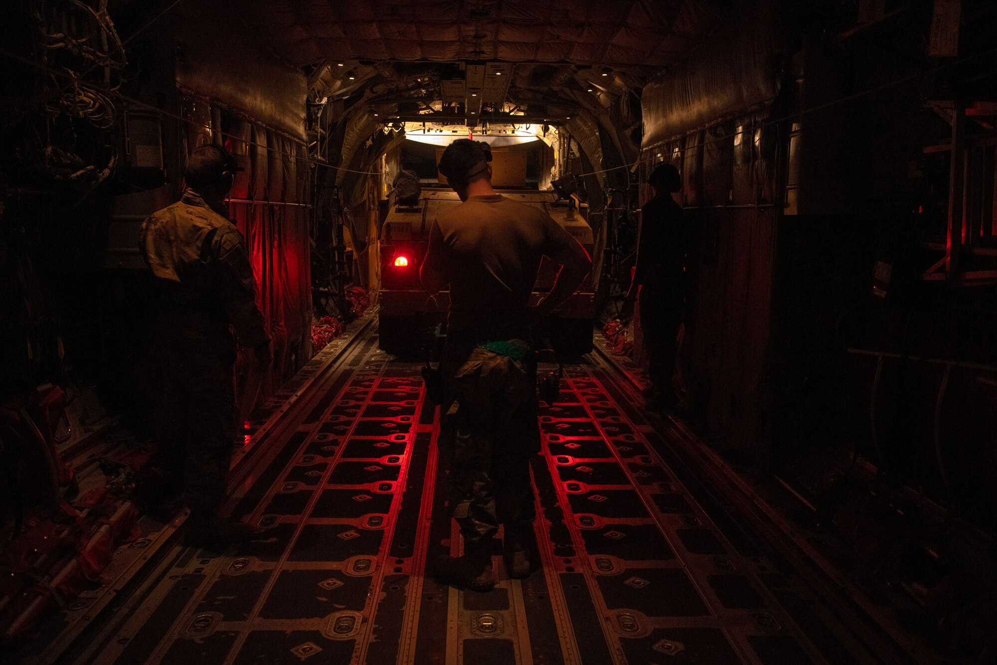 man guiding truck onto plane