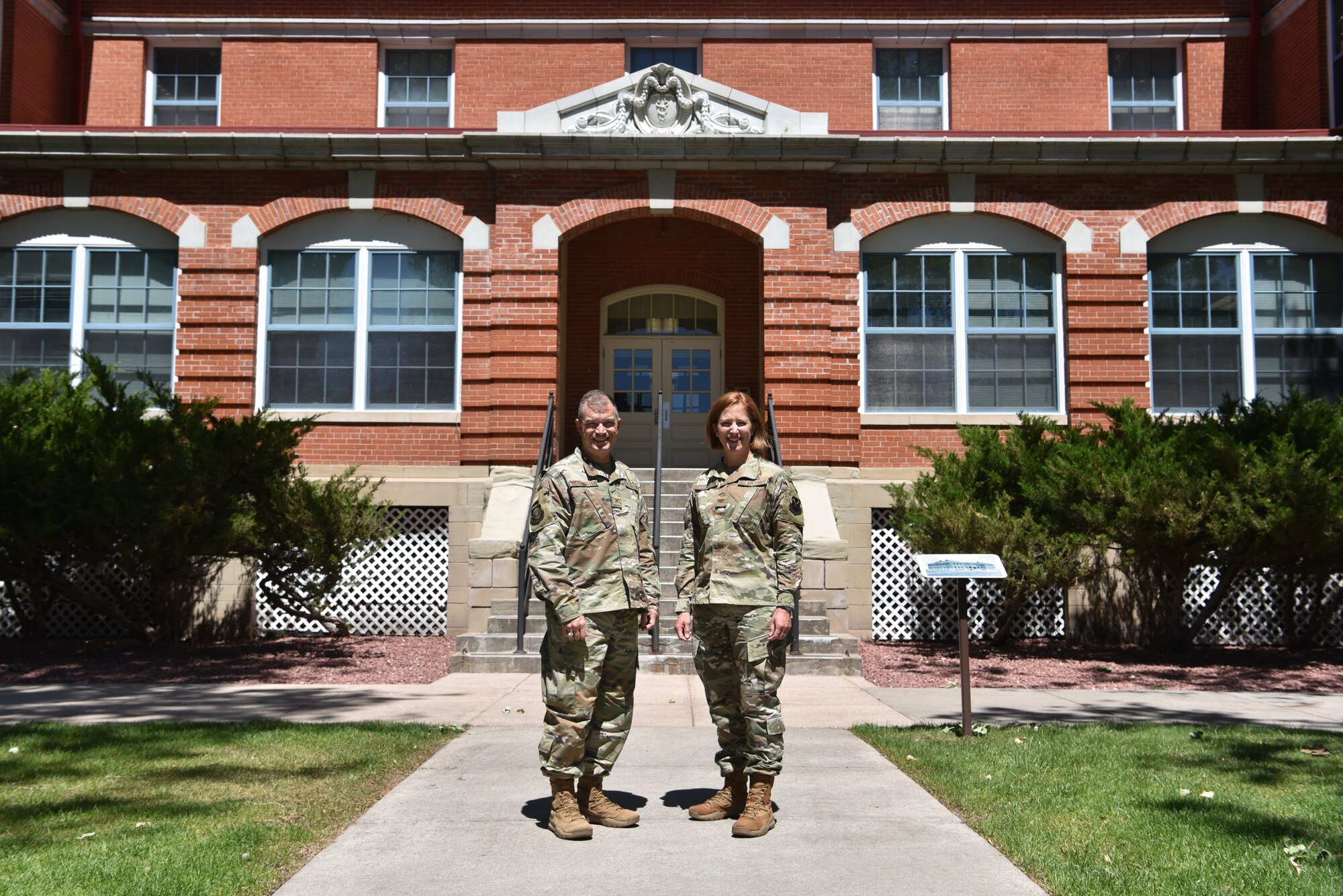Servicemembers stand in front of 20 AF headquarters.