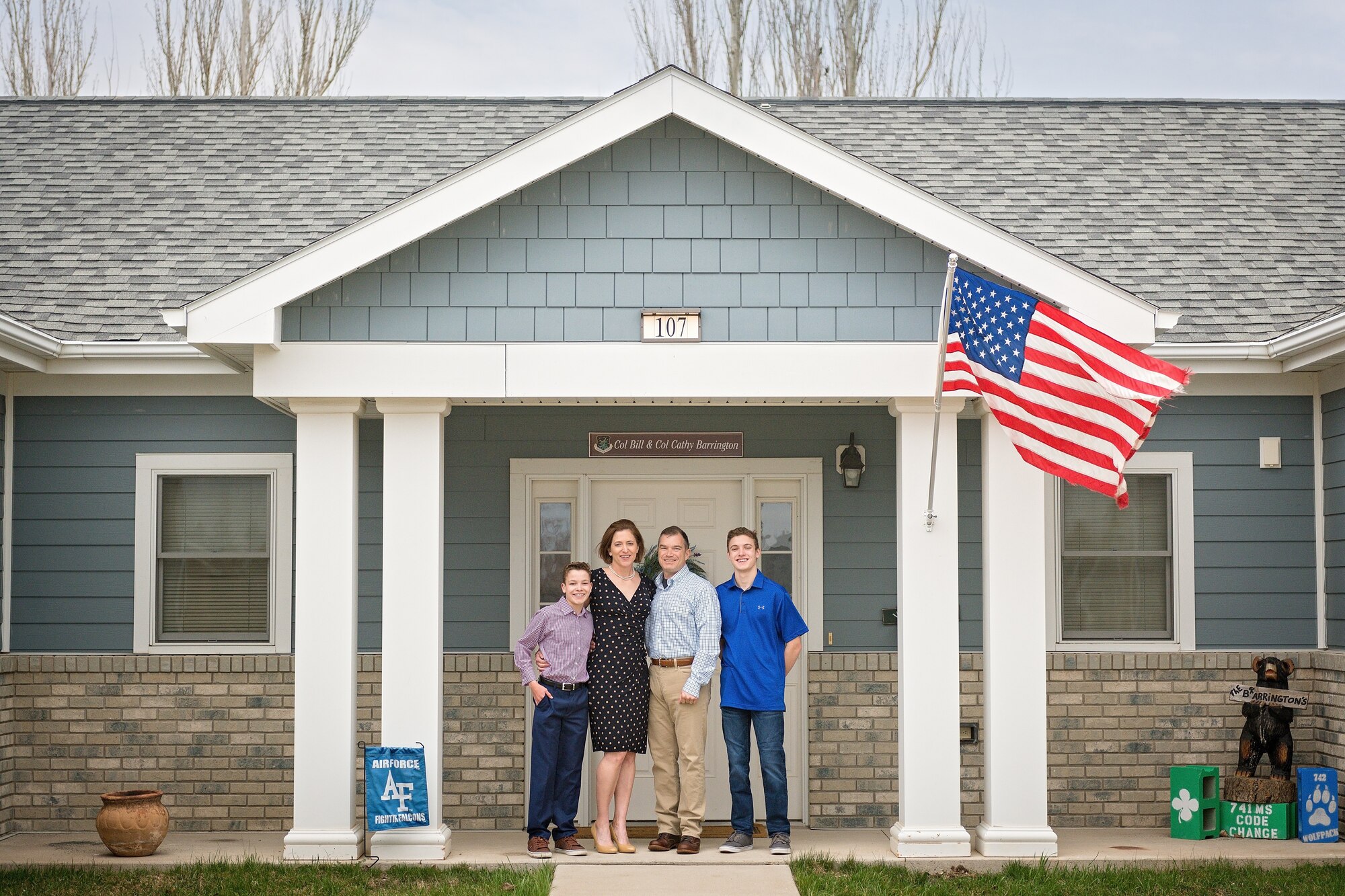 A family stands in front of their house.