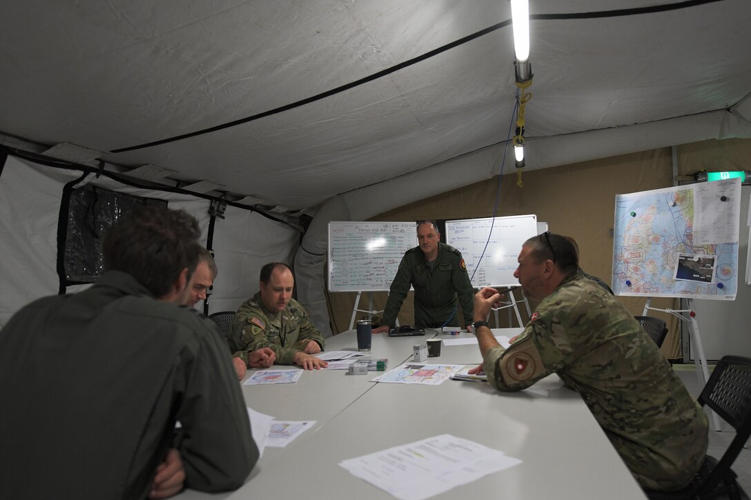 Participants of a combined readiness exercise in the Baltic region conduct a mission briefing at Aalborg Air Base, Denmark, Oct. 31, 2020. The exercise enhances the proficiency of multinational forces to counter military aggression and coercion by sharing responsibilities for common defense. (U.S. Air Force photo by Senior Airman Shanice Ship)