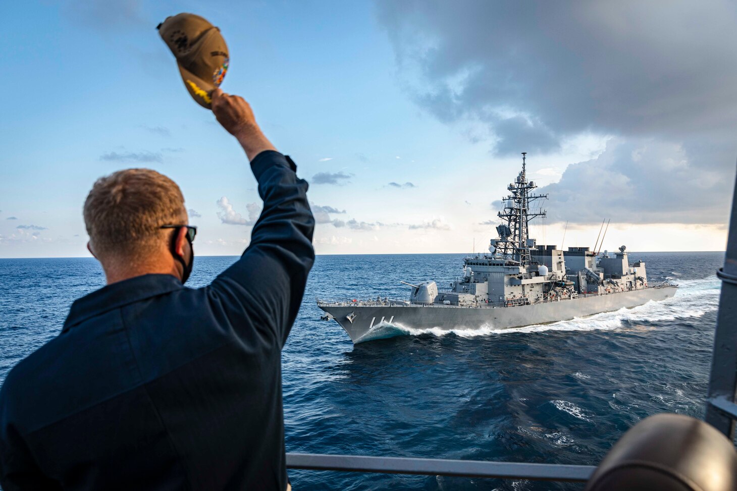 Cmdr. Ryan T. Easterday, commanding officer of the Arleigh Burke-class guided-missile destroyer USS John S. McCain (DDG 56) waves to the Takanami-class destroyer JS Oonami (JS 111) as it makes its approach during divisional tactics while conducting integrated operations. McCain is assigned to Destroyer Squadron Fifteen (DESRON 15), the Navy’s largest forward-deployed DESRON and the U.S. 7th Fleet’s principal surface force.