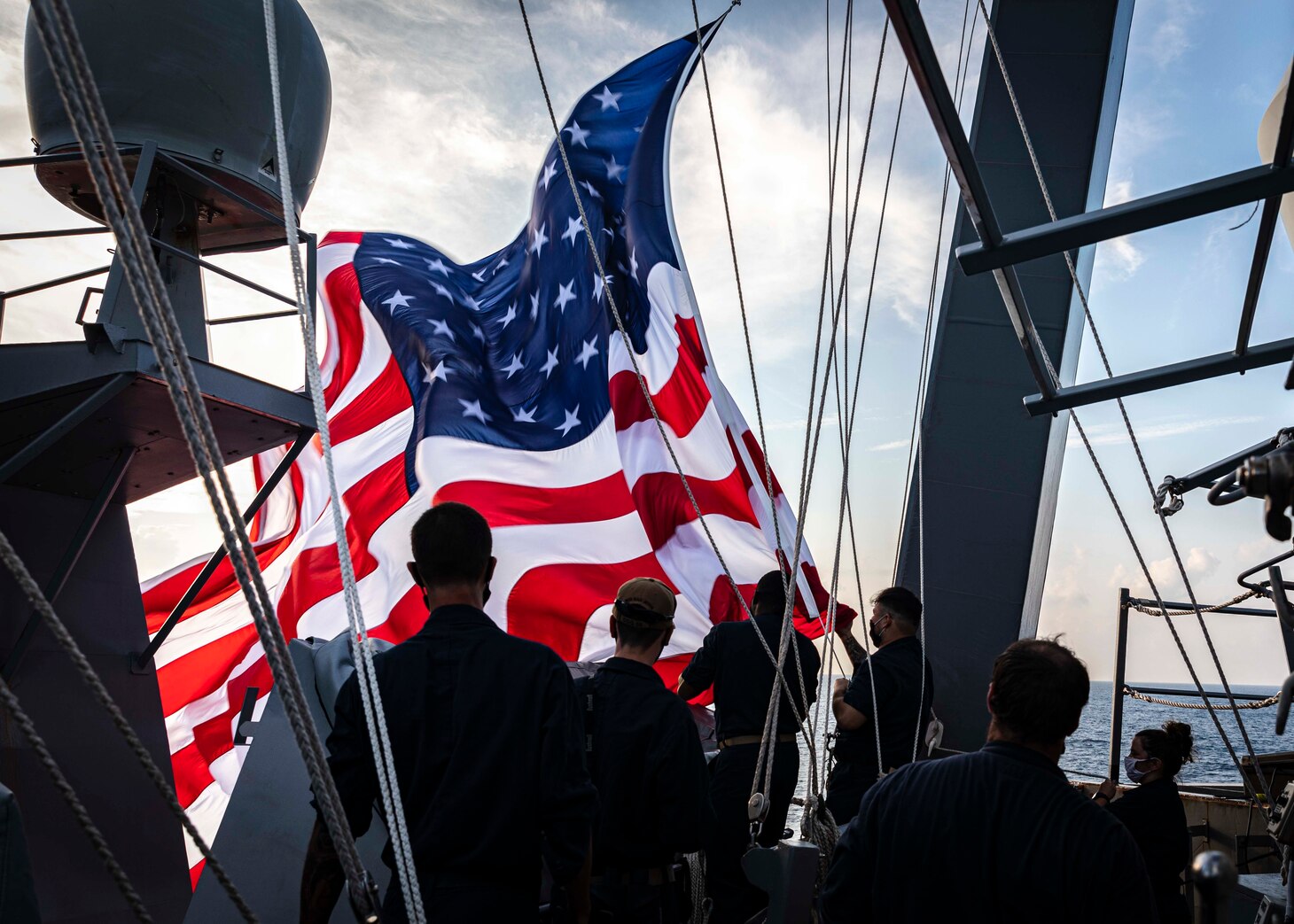 Sailors haul down the battle ensign on the bridge wing aboard the Arleigh Burke-class guided-missile destroyer USS John S. McCain (DDG 56). McCain is assigned to Destroyer Squadron Fifteen (DESRON 15), the Navy’s largest forward-deployed DESRON and the U.S. 7th Fleet’s principal surface force.