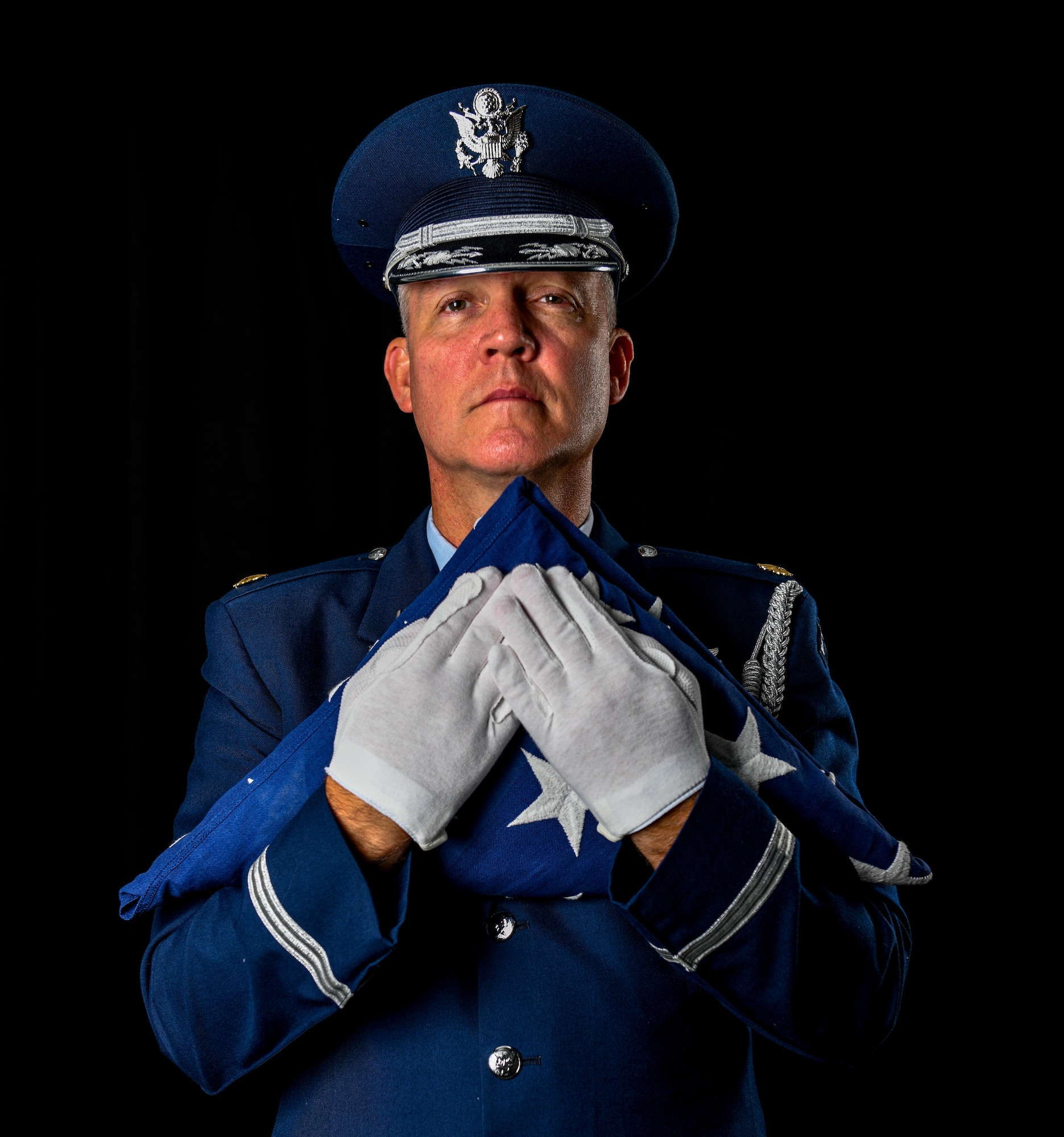 Maj. Scott Allen, 910th Airlift Wing public affairs officer, holds a folded American flag, Aug. 21, 2020, at Youngstown Air Reserve Station, Ohio.
