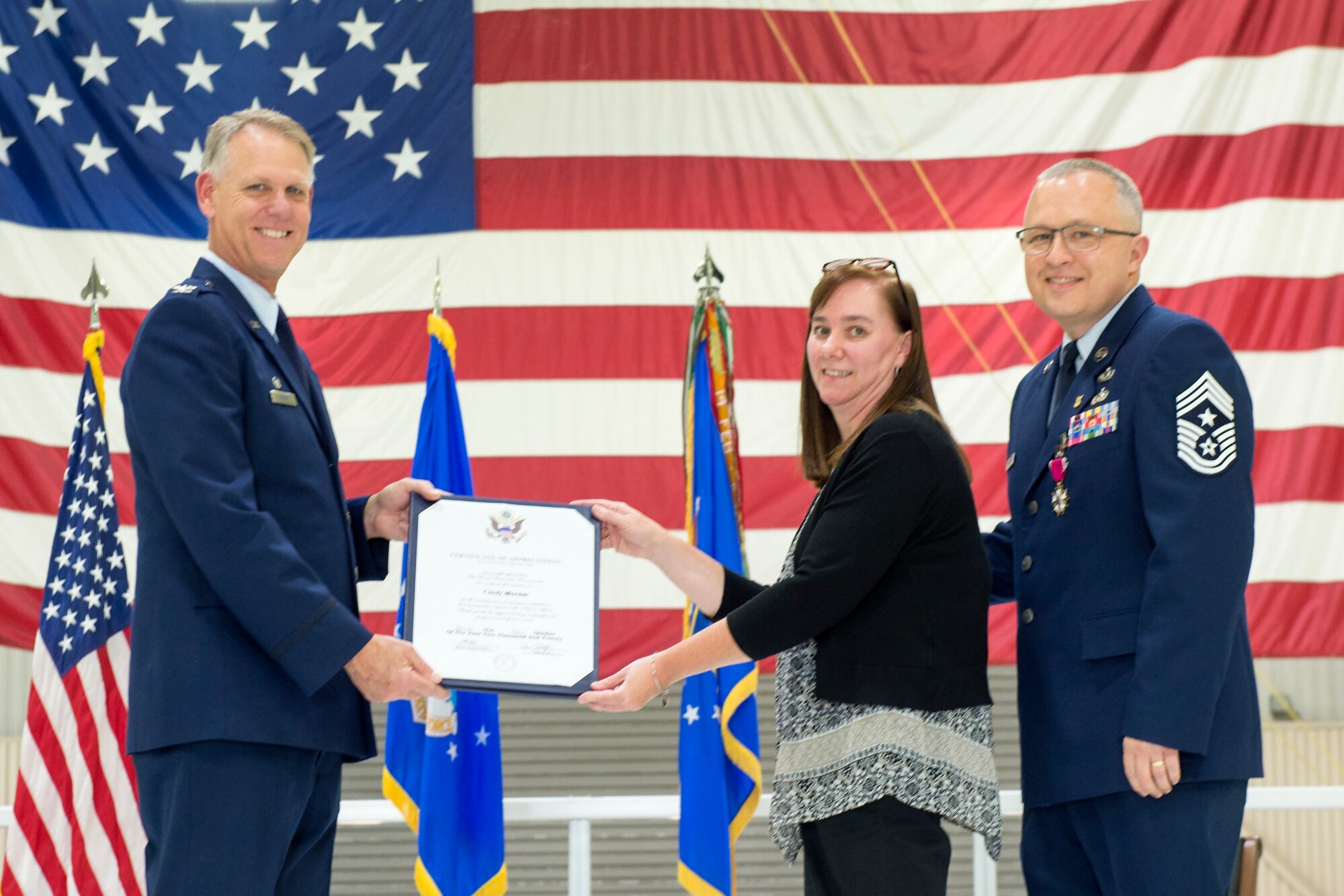 Col. Larry Shaw, 434th Air Refueling Wing commander, presents Cindy Marion, wife of Chief Master Sgt. Wes Marion, 434th ARW command chief, with a certificate of appreciation during her husband’s retirement ceremony at Grissom Air Reserve Base, Ind., Nov. 8, 2020. In addition to supporting her husband’s military career, Cindy supported all of Grissom Airman by serving in the Key Spouse program since 2016 as a Key Spouse Wing mentor. (U.S. Air Force photo/Master Sgt. Ben Mota)