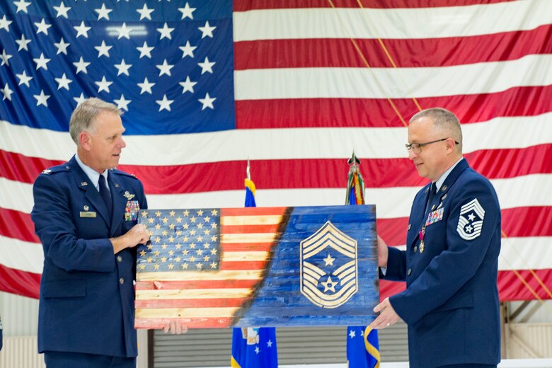 Col. Larry Shaw, 434th Air Refueling Wing commander, presents Chief Master Sgt. Wes Marion, 434th ARW command chief, with a gift during his retirement ceremony at Grissom Air Reserve Base, Ind., Nov. 8, 2020. During the ceremony Shaw lauded Marion for his superior leadership and his dedication to his Airman. (U.S. Air Force photo/Master Sgt. Ben Mota)