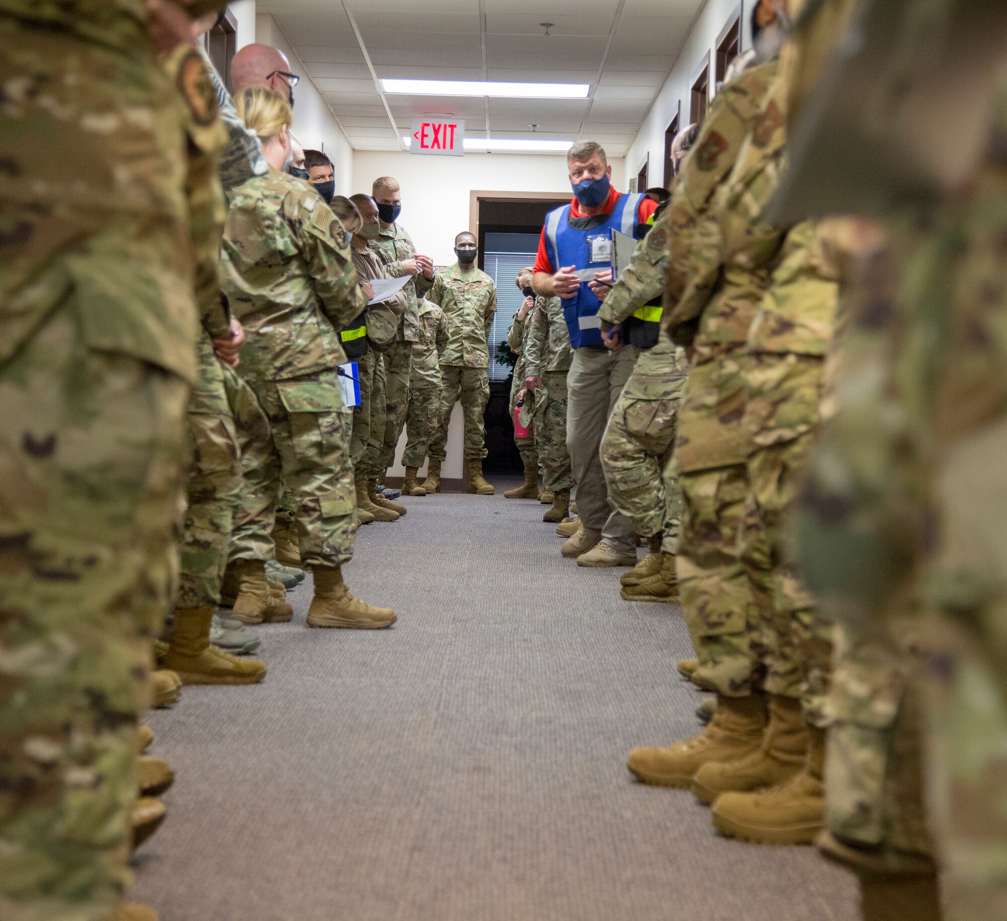 Kirk Johnson, seen center in blue vest, an anti-terrorism expert with Department of Emergency on Joint Base Lewis-McChord, Washington, discusses overall performance during the exercise with members of the 446th Force Support Squadron following an active shooter exercise Nov. 7, 2020 here.