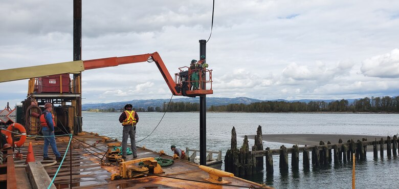 Contractors installing king pile markers