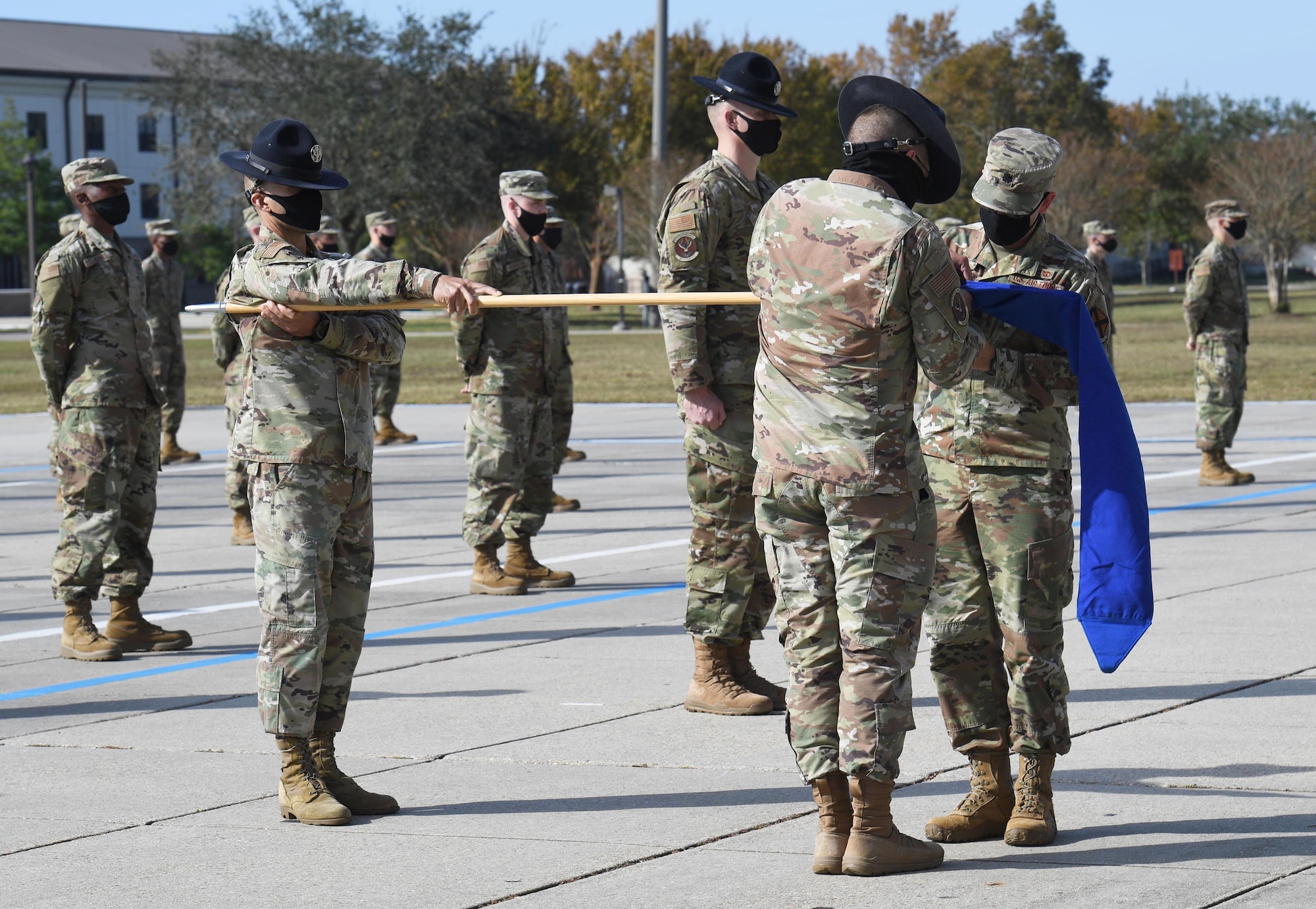 U.S. Air Force Tech. Sgt. Isaiah Smith, 37th Training Wing Detachment 5 military training instructor, and Lt. Col. Benjamin Werner, 737th Training Group Detachment 5 commander, deactivate the 737th TRG Detachment 5 flag during the final BMT graduation ceremony on the Levitow Training Support Facility drill pad at Keesler Air Force Base, Mississippi, Nov. 6, 2020. Nearly 60 trainees from the 37th TRW Detachment 5 completed the six-week BMT course. Throughout the duration of BMT training at Keesler, 18 flights and 939 Airmen graduated. (U.S. Air Force photo by Kemberly Groue)