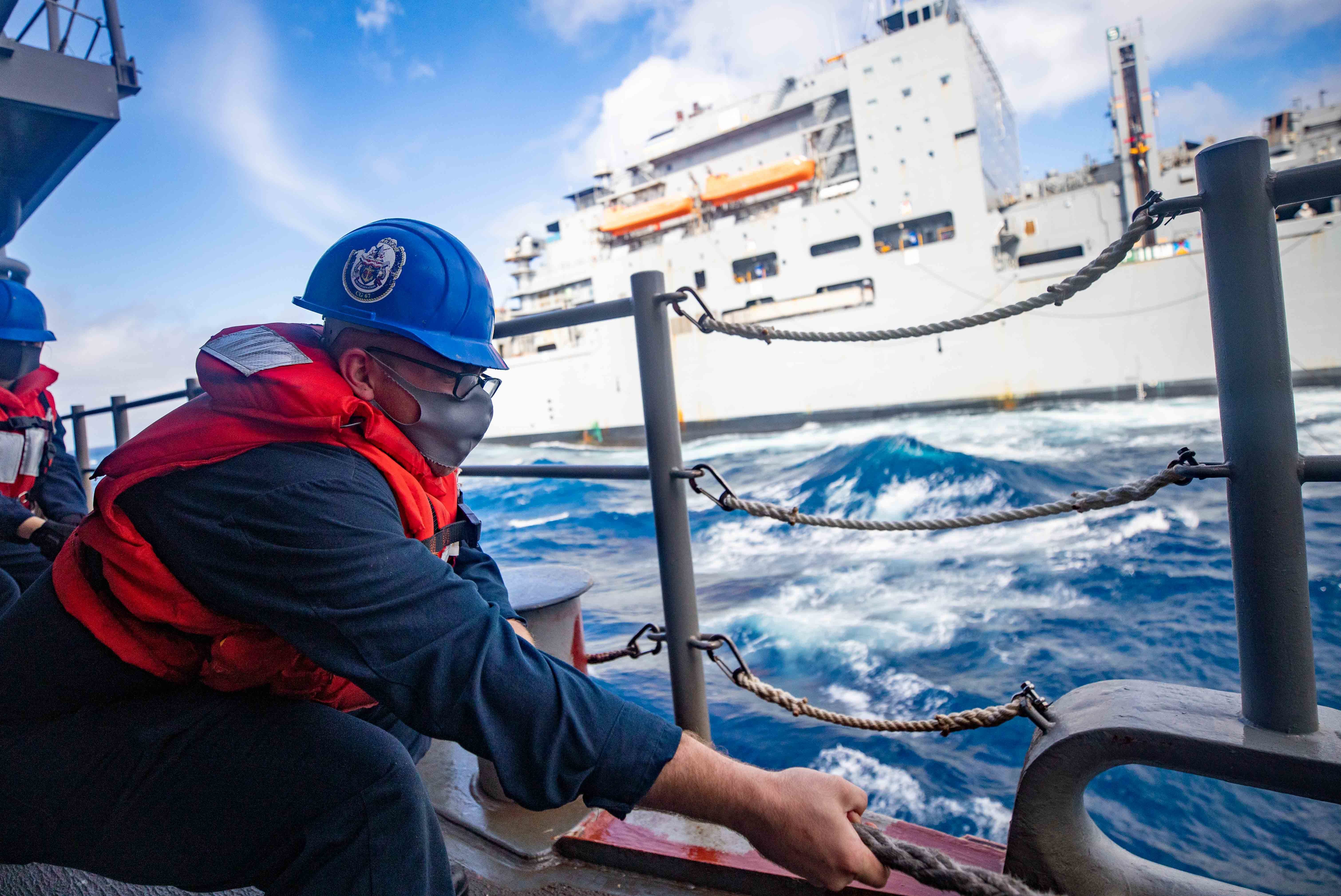 Cryptologic Technician (Technical) Seaman Jacob Fischer, from Detroit, heaves a line aboard the Ticonderoga-class guided-missile cruiser USS Shiloh (CG 67) during a replenishment-at-sea with the dry cargo and ammunition ship USNS Charles Drew (T-AKE 10).