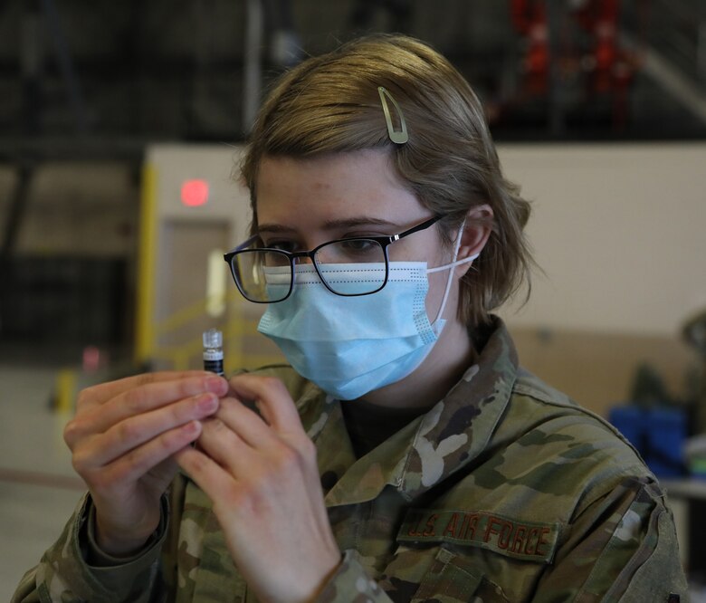 U.S. Air Force Senior Airman Julia Stephenson, an aerospace medical technician with the 446th Aeromedical Staging Squadron here, checks a flu shot vaccine for air bubbles Nov. 8, 2020.