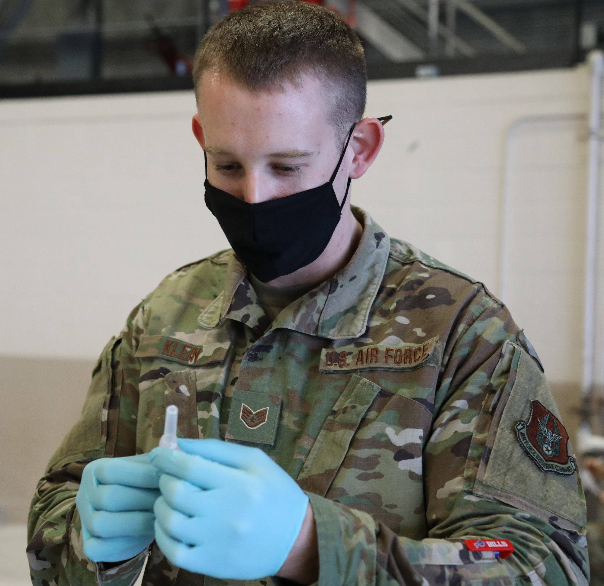 U.S. Air Force Staff Sgt. Shayne Klein, an aerospace medical technician with the 446th Aerospace Medicine Squadron here, puts a needle on a flu shot vaccine Nov. 8, 2020.