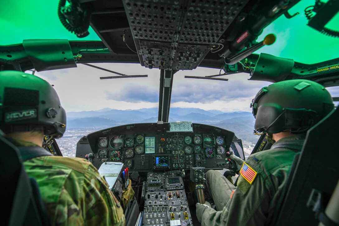 Pilots fly a UH-1N Iroquois helicopter during search and rescue training.