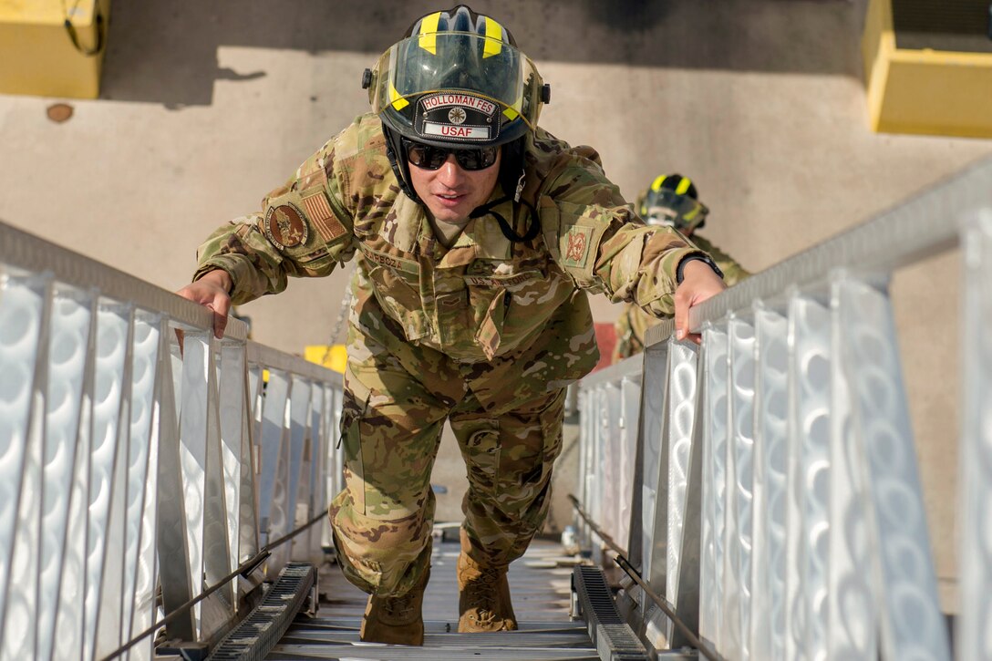 An airman climbs a ladder.