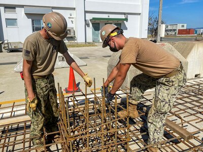 Utilitiesman 3rd Class Brandon Kimpel, from Huntley, Ill., and Utilitiesman Constructionman Austin Carter, from Fairview, Mich., assigned to U.S. Naval Mobile Construction Battalion (NMCB) 3 Detail Sasebo, fabricate rebar pedestals for the construction of a pre-engineered building that will serve as a maintenance facility for Naval Beach Unit 7.