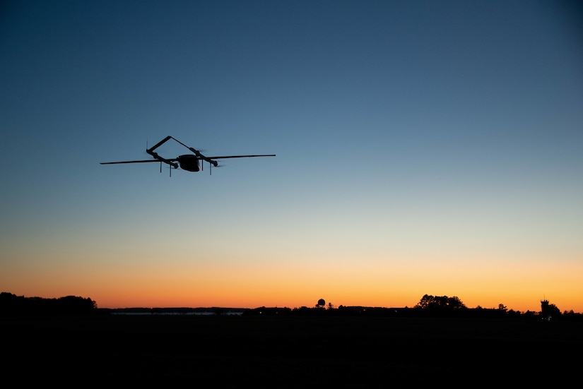 A small aircraft flies into the sunset.