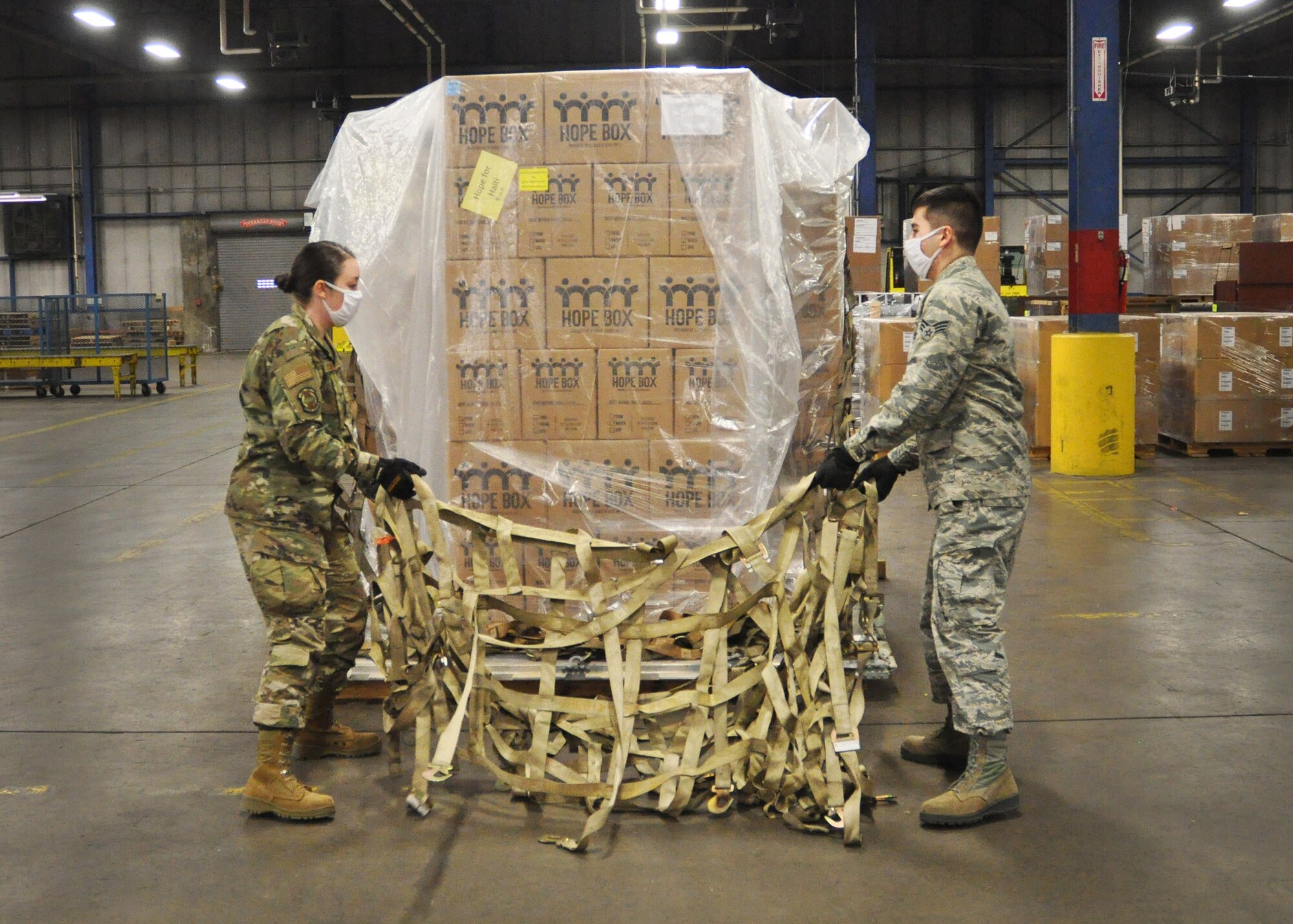 Senior Airmen Mariah Blankenship and Dan Iwamoto, both 87th Aerial Port Squadron cargo handling technicians, prepare a pallet of Hope Boxes destined for Port-au-Prince, Haiti. Each individual Hope Box contains nutritious food for 216 meals, along with a water filtration system to purify 100 gallons of water. In all, the 87th APS processed more than 300 Hope Boxes during the October UTA.