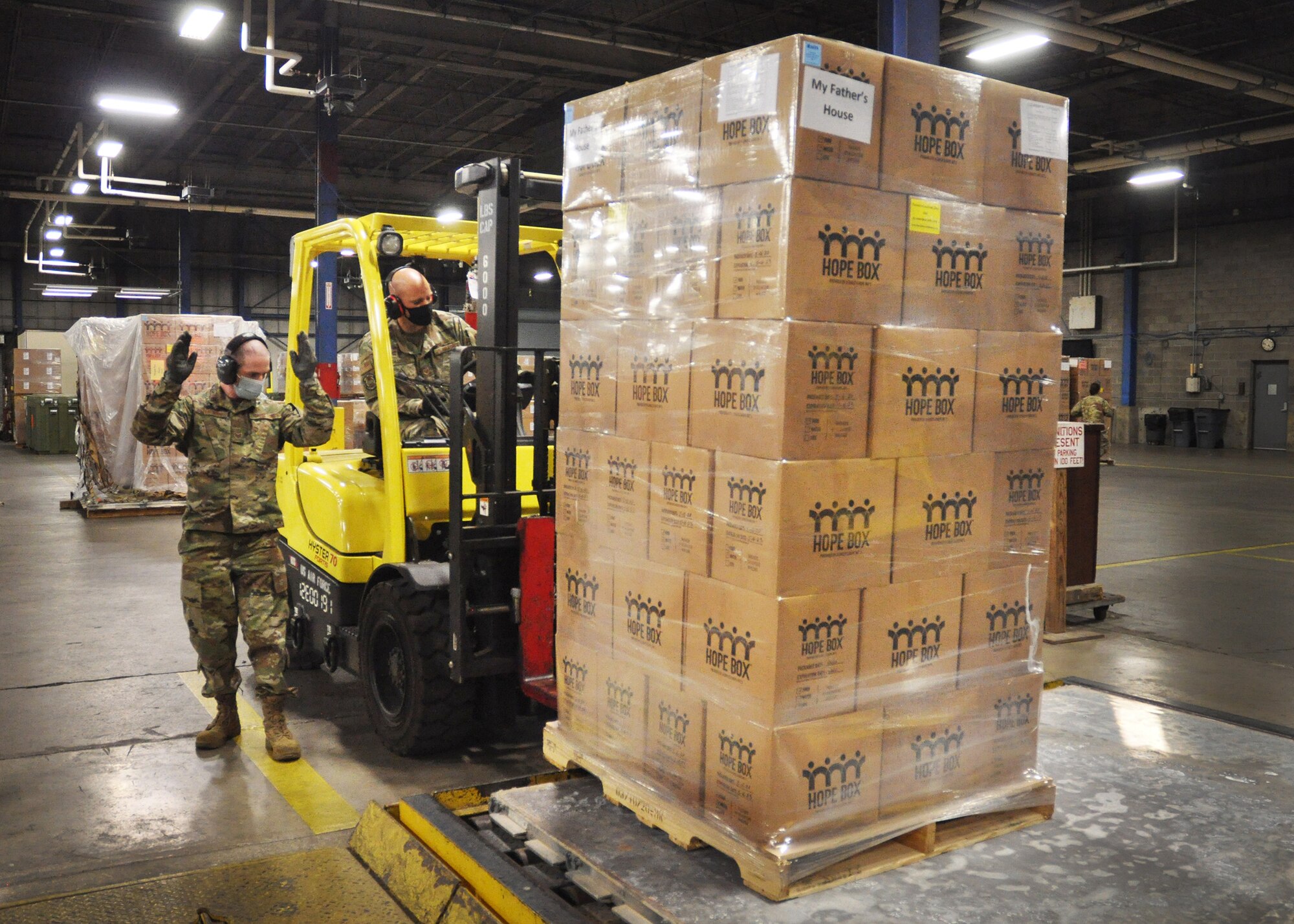 Staff Sgt. Matt Fehrman guides Staff Sgt. Kirk Laytart as he places a skid of 66 Hope Boxes onto a pallet in preparation for military airlift to Port-au-Prince, Haiti. The Hope Boxes, provided by A Child’s Hope International in Cincinnati, contain water filtration kits to purify a collective 30,000 gallons of water, as well as 64,000 meals. These Hope Boxes were handpacked in June and have a shelf life on three years. Airlifted on a space-available basis as part of the Denton program, the boxes will be picked up by nonprofit agencies in Haiti and distributed to children and families.