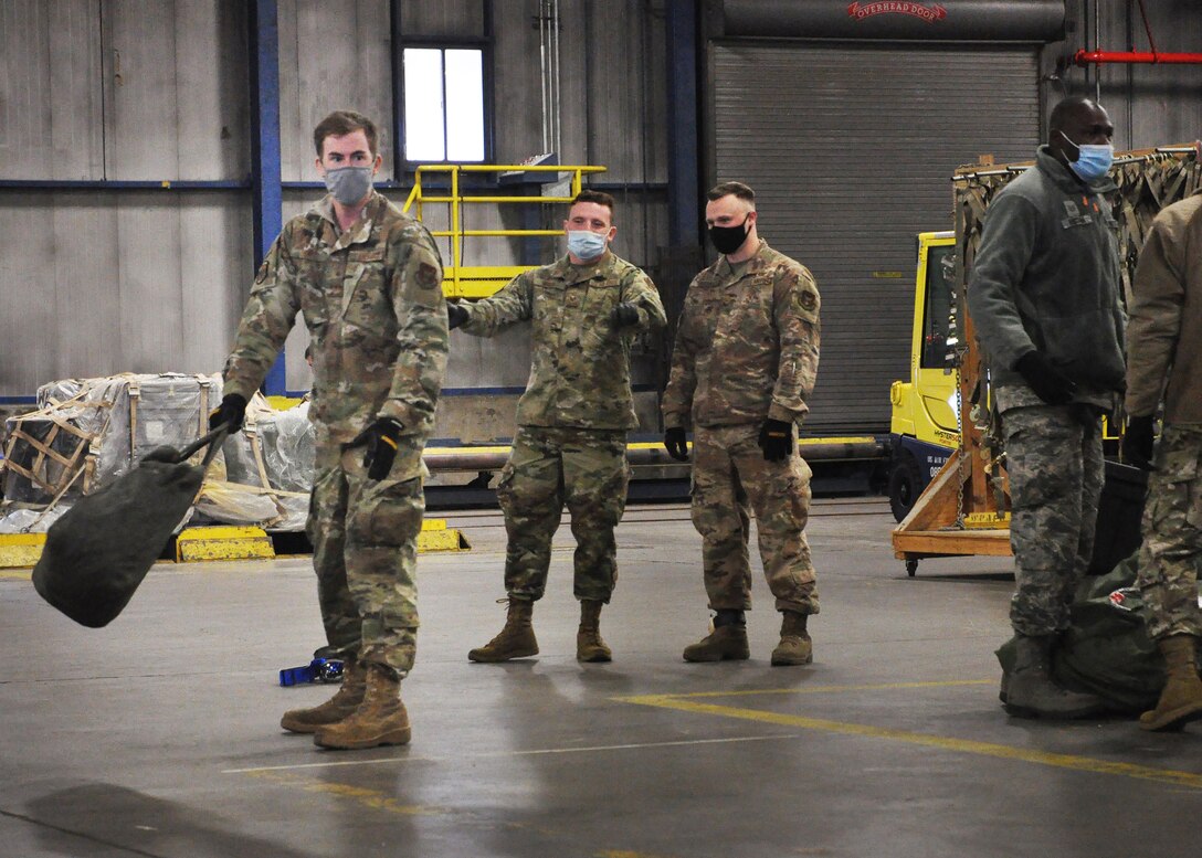 Staff Sgt. Edward Dunn, 87th Aerial Port Squadron fleet specialist, prepares to toss a bag across the cargo warehouse as part of the 87th Aerial Port Squadron’s semi-annual Port Dawg Challenge Oct. 17, 2020. The bag toss was one of several events designed to strengthen camaraderie and teamwork among squadron members.
