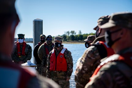 Gen. Jacqueline Van Ovost, Air Mobility Command commander, listens to a safety briefing before taking a boat tour with harbor patrol, Nov. 4, 2020, at Joint Base Charleston, S.C. Van Ovost, her husband Alan Frosch, and Chief Master Sgt. Brian Kruzelnick, AMC command chief, visited members of Joint Base Charleston as part of their listening tour. Their trip centered on meeting members of Team Charleston, highlighting their accomplishments and learning about their specific mission sets.