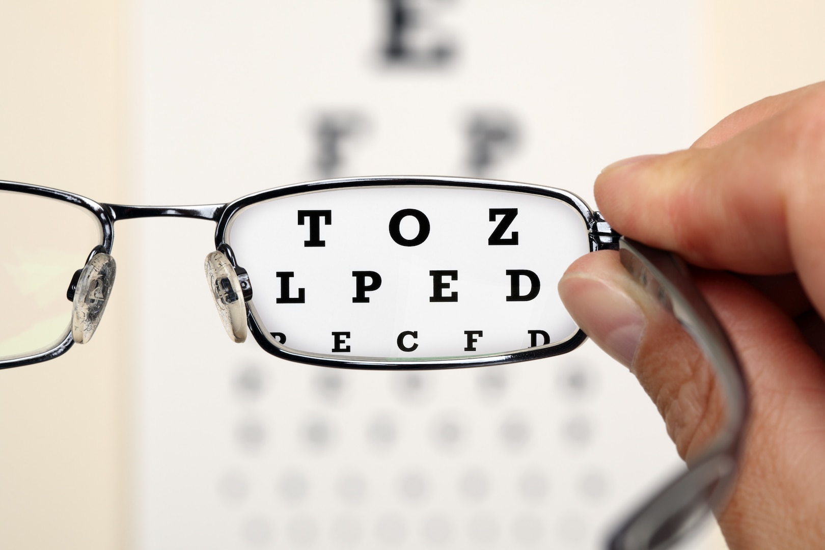 Looking through glasses at an eye exam chart