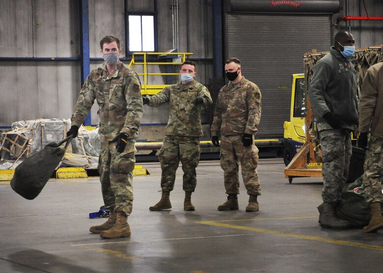 Staff Sgt. Edward Dunn, 87th Aerial Port Squadron fleet specialist, prepares to toss a bag across the cargo warehouse as part of the 87th Aerial Port Squadron’s semi-annual Port Dawg Challenge Oct. 17, 2020. The bag toss was one of several events designed to strengthen camaraderie and teamwork among squadron members.