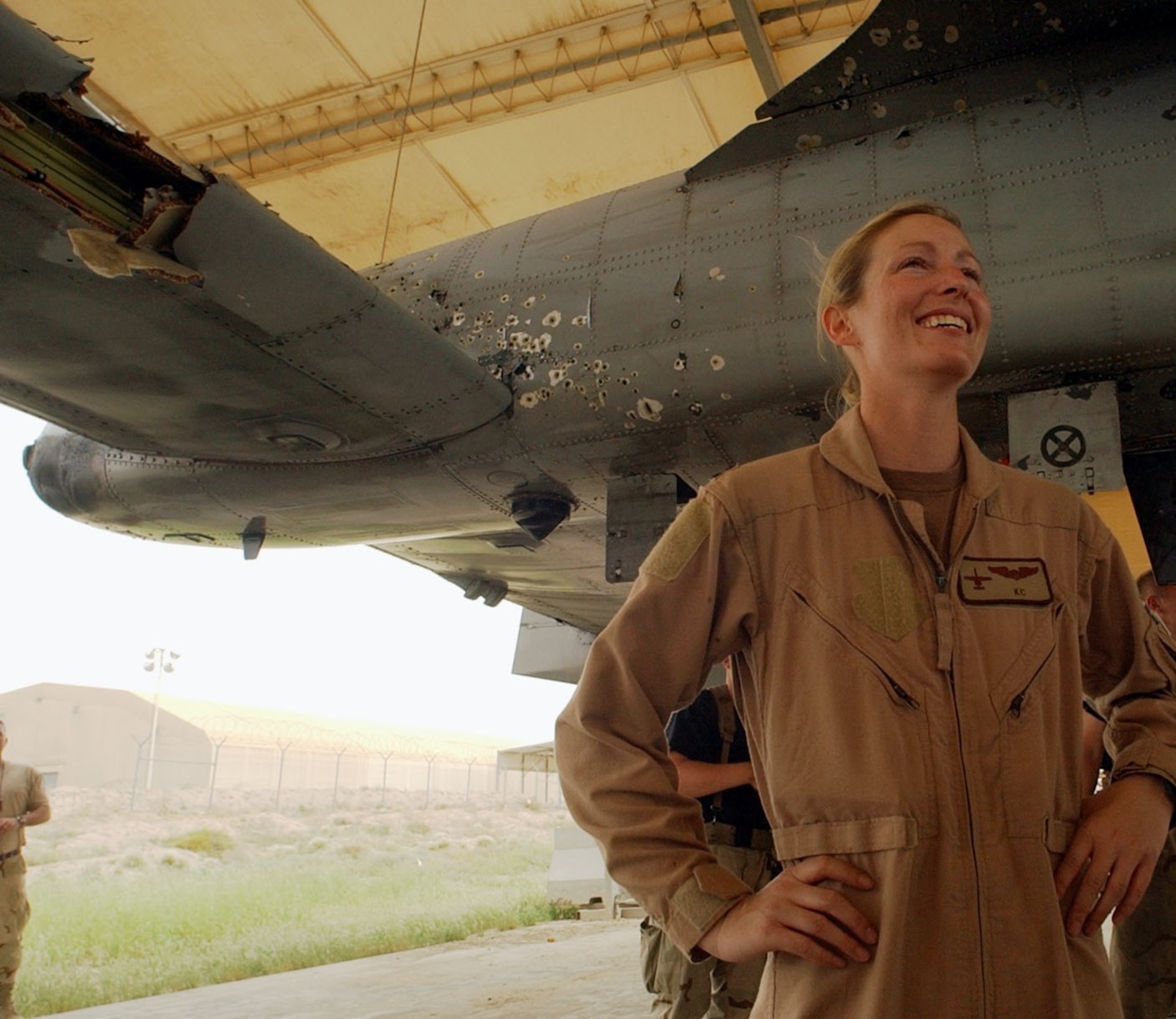 Col. Kim Campbell, Director of the Center for Character and Leadership Development, poses with her damaged A-10 Thunderbolt II after a 2003 combat mission in Iraq. Campbell is a 1997 graduate and command pilot with over 1,700 hours in the A-10.