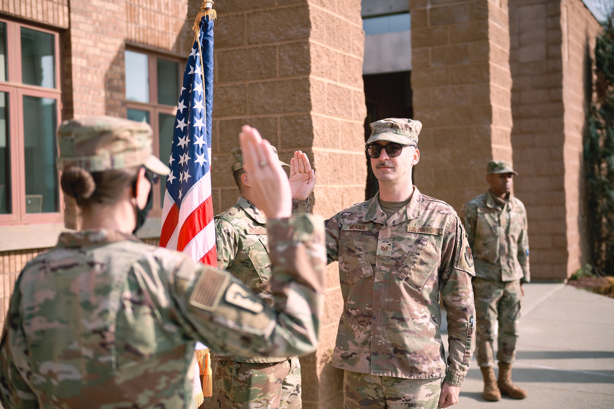 Maj. Meghan Smith, chief of public affairs for the 158th Fighter Wing, Vermont Air National Guard, conducts the oath of enlistment for Tech. Sgt. Richard Mekkri.