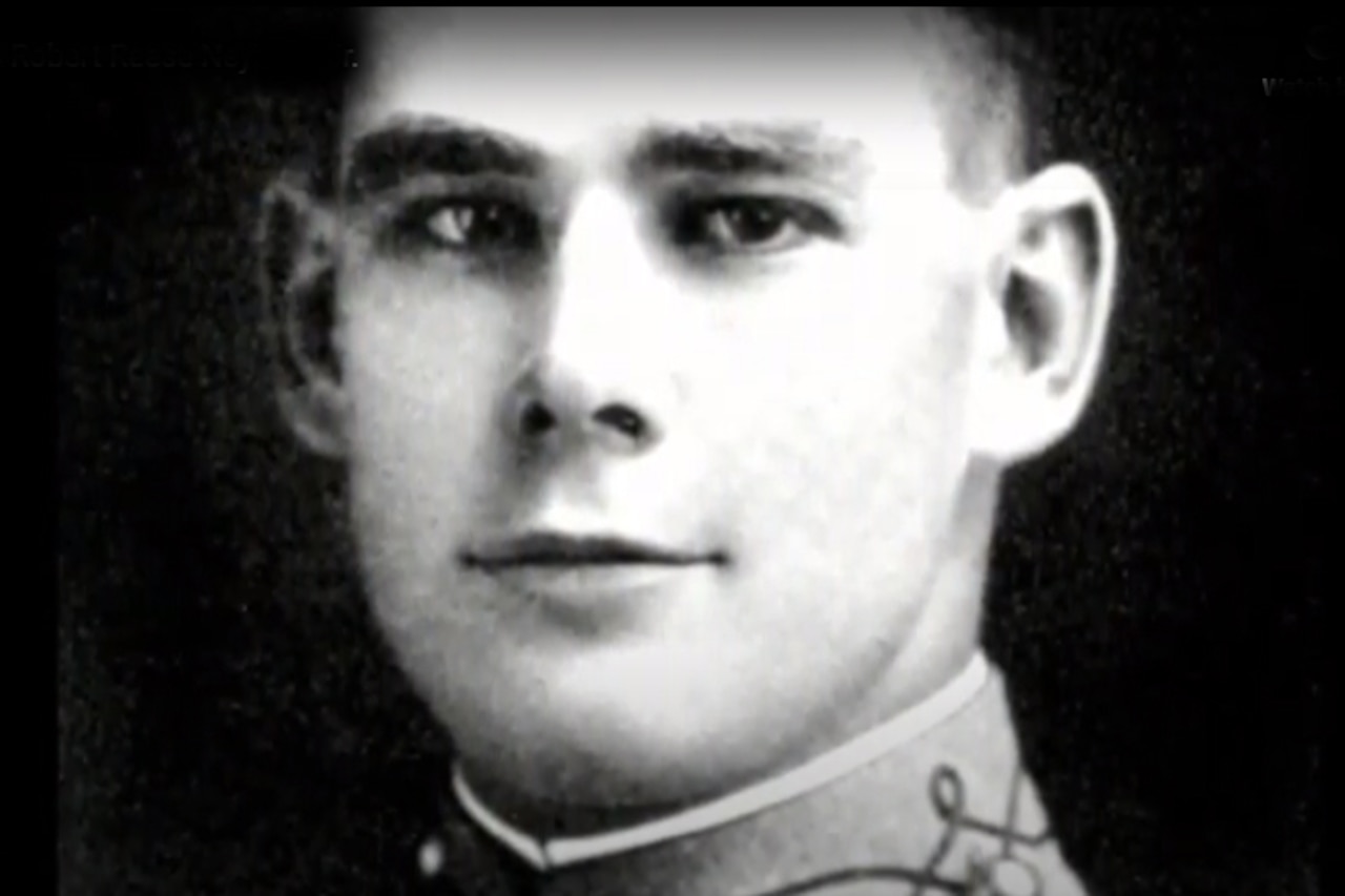 A man in a West Point cadet’s uniform poses for a photo.