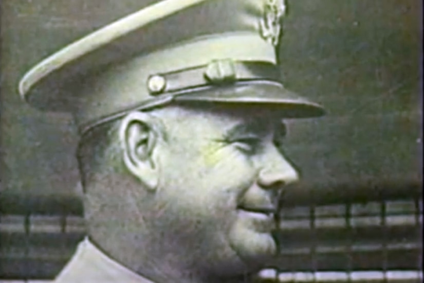 A man in a military uniform poses for a photo.