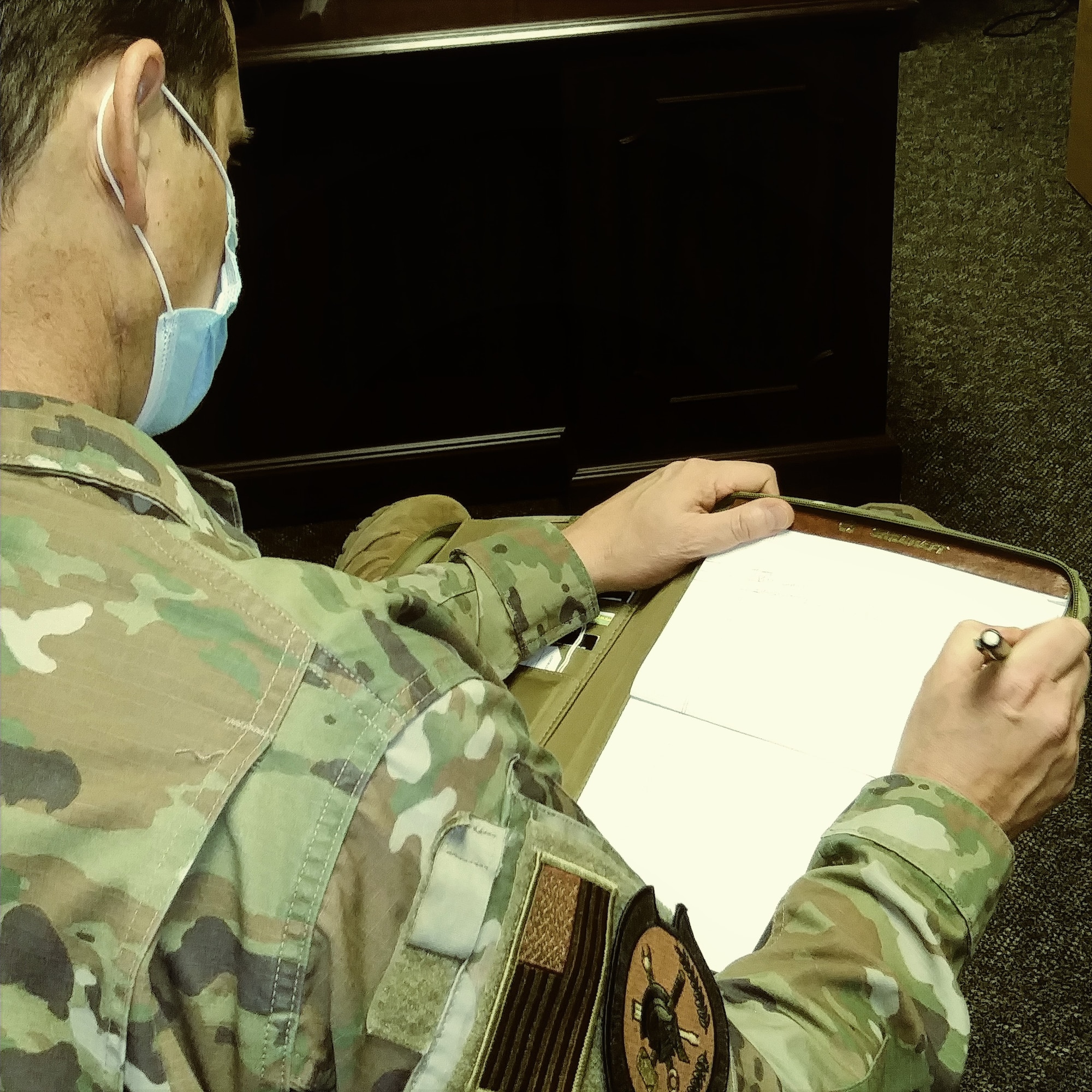 Chief Master Sgt. Daniel McCarthy takes notes in one of the wing's headquarters offices during the biography writing class.