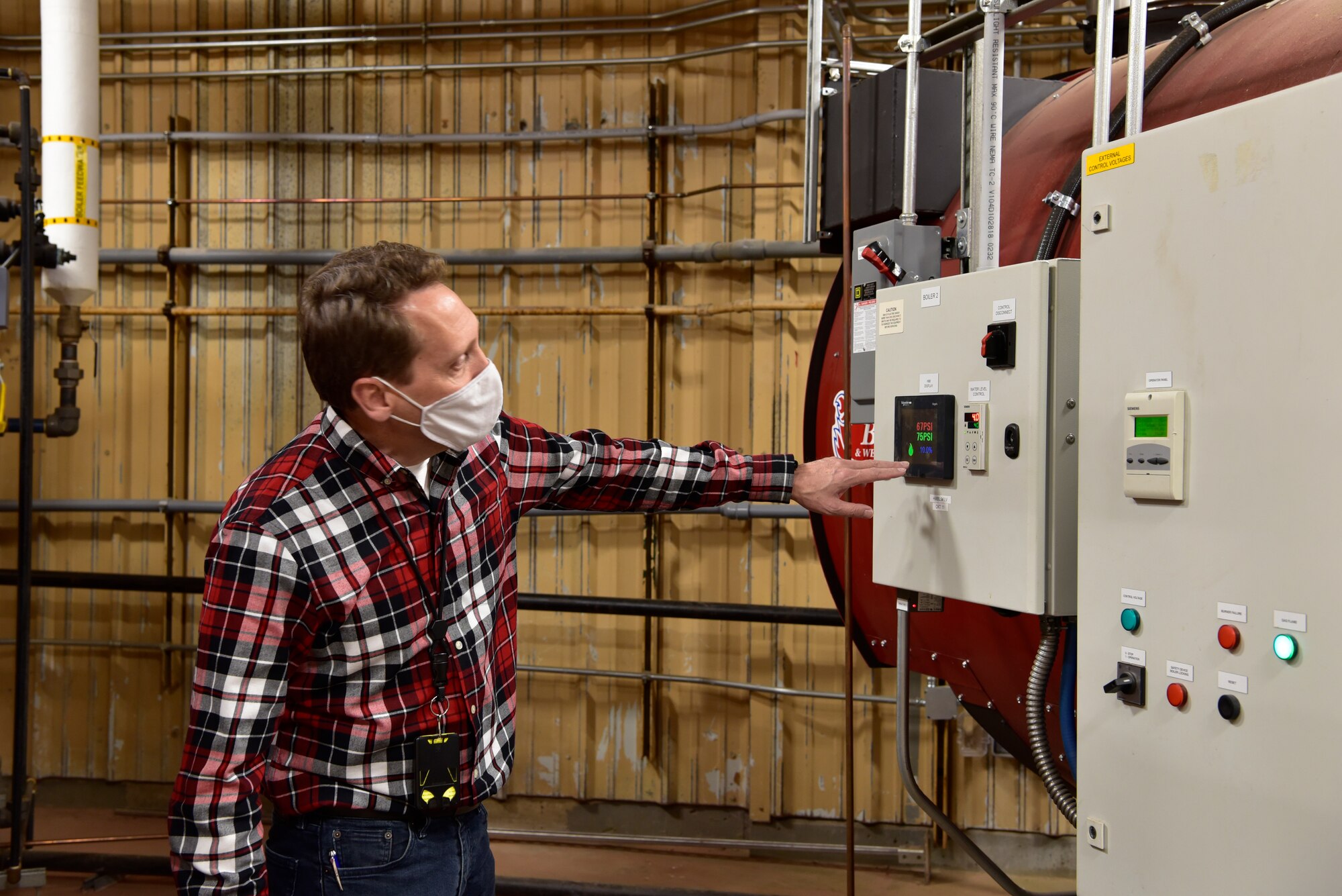Joseph Cecrle, OC-ALC energy manager, checks the control panel on a new process steam boiler in one of many distributed systems that replaced the old centralized steam plant.