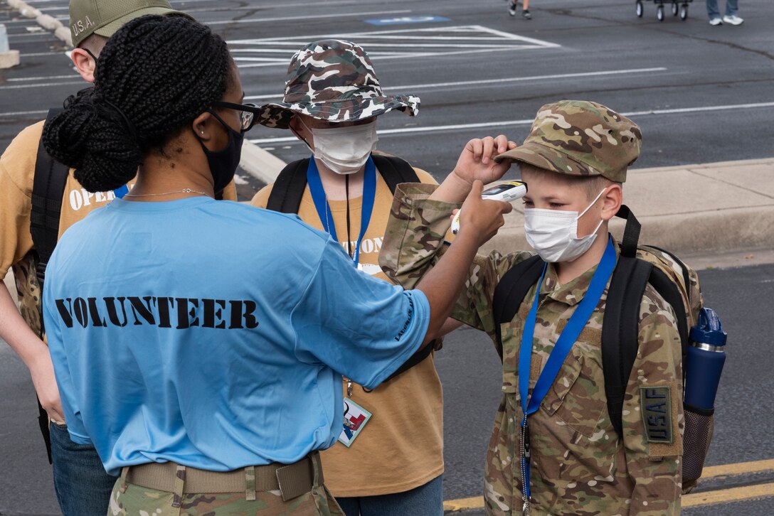 Airman 1st Class Olleah Brown, 47th Healthcare Operations Squadron laboratory technician, scans a junior deployer’s forehead to check his temperature before he enters a station on Nov. 7, 2020 at Laughlin Air Force Base, Texas. A volunteer took atendee’s temperatures at each station to monitor for symptoms of COVID-19. (U.S. Air Force photo by Senior Airman Anne McCready)