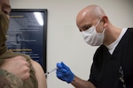 Tech Sgt. Robert Carpenter, 59th Medical Wing Immunizations Clinic licensed vocational nurse, administers the influenza vaccine to a patient.