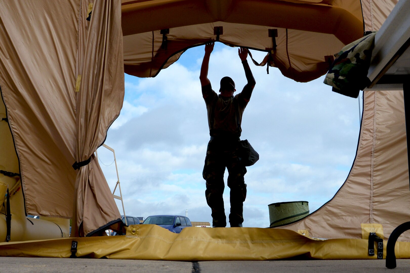 Staff Sgt. Louis Tirado, 433rd Operations Support Squadron aircrew flight equipment technician, prepares a decontamination line for readiness training with the 68th Airlift Squadron Nov. 8, 2020, at Joint Base San Antonio-Lackland, Texas. The decontamination line consists of four stations where AFE technicians work to safely decontaminate Airmen from toxic substances. (U.S. Air Force photo by Tech. Sgt. Samantha Mathison)