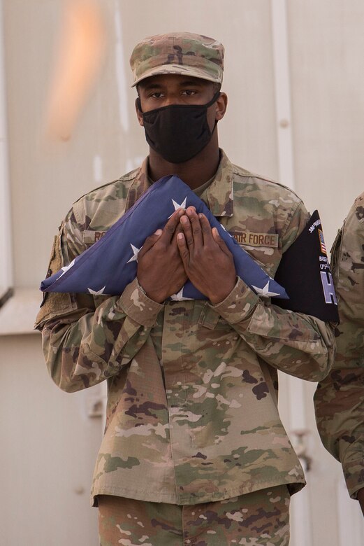 U.S. Air Force Senior Airman Chance Roberts, 380th Expeditionary Logistics Readiness Squadron vehicular maintenance journeyman and 380th Air Expeditionary Wing Honor Guardsman, clutches an American flag as part of a retreat ceremony in honor of Veterans Day at Al Dhafra Air Base, United Arab Emirates, Nov, 11, 2020.