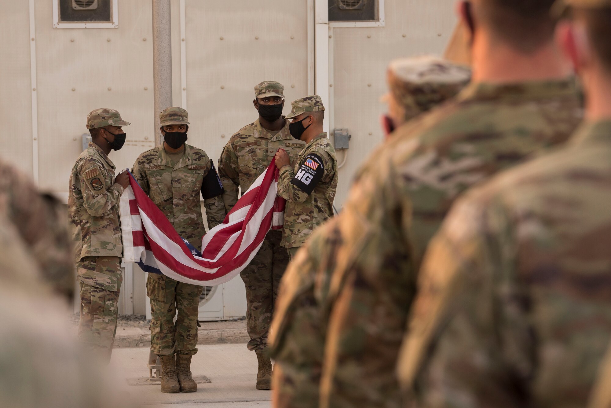 Members of the 380th Air Expeditionary Wing Honor Guard fold an American flag as part of a retreat ceremony in honor of Veterans Day at Al Dhafra Air Base, United Arab Emirates, Nov, 11, 2020.