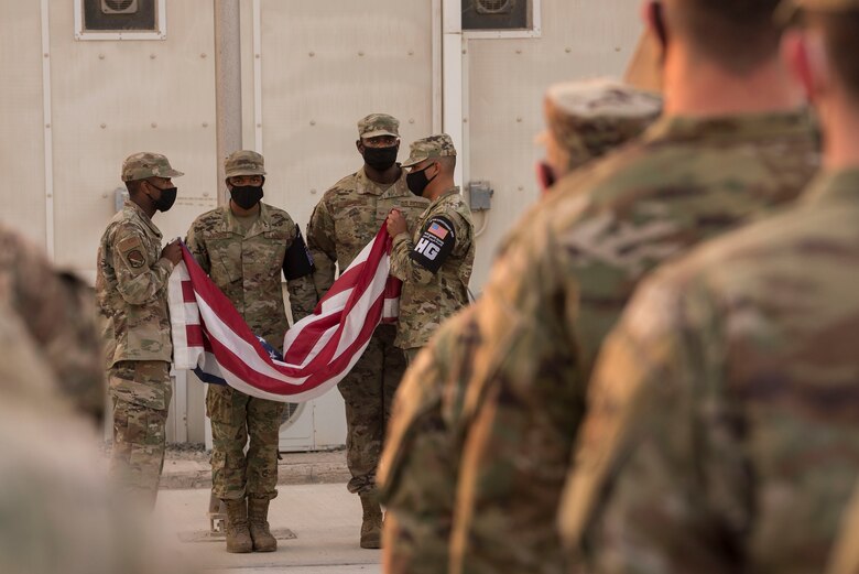 Members of the 380th Air Expeditionary Wing Honor Guard fold an American flag as part of a retreat ceremony in honor of Veterans Day at Al Dhafra Air Base, United Arab Emirates, Nov, 11, 2020.