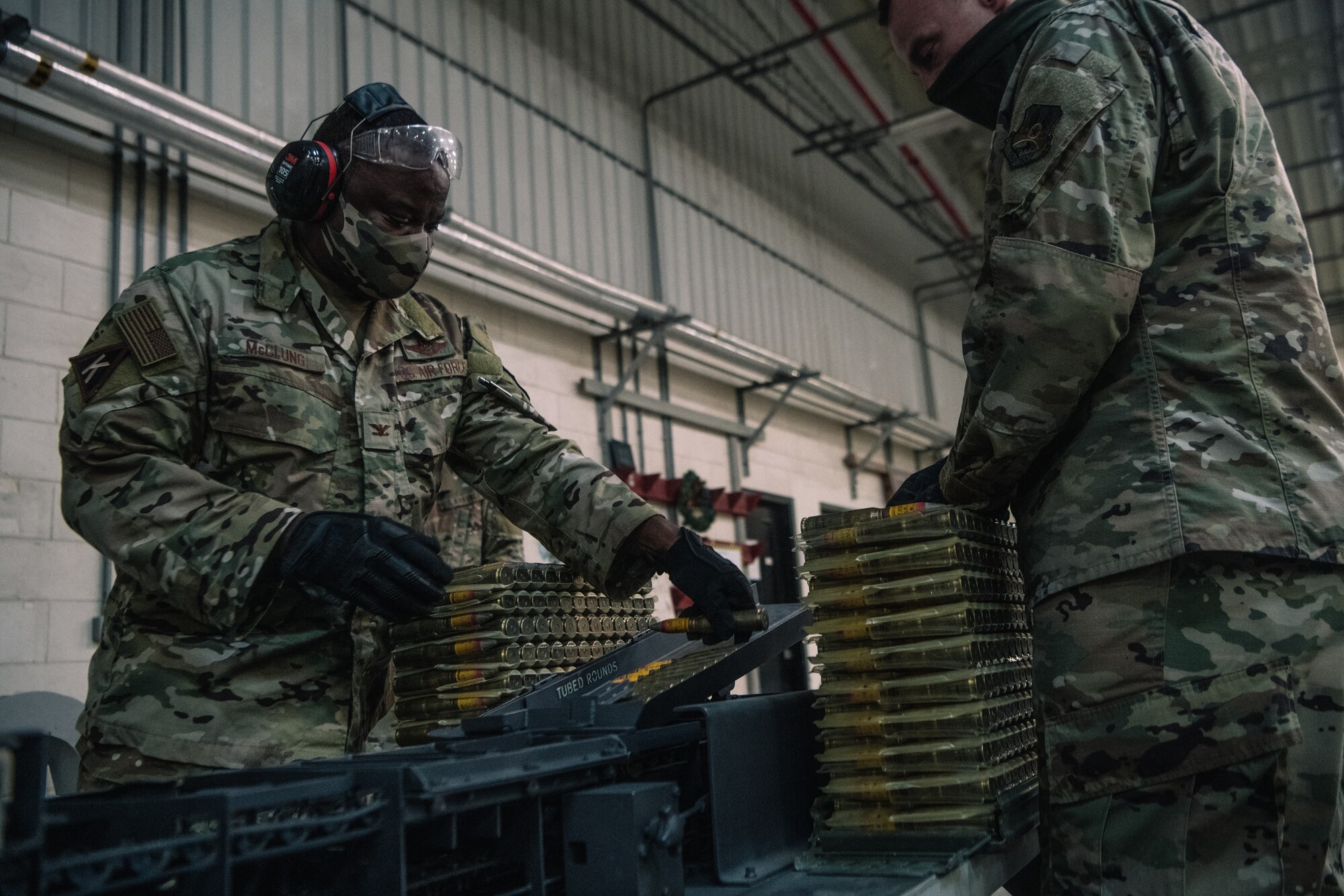 U.S. Air Force Col. John C. McClung, left, 379th Air Expeditionary Wing Vice Commander, and Chief Master Sgt. Michael Sullivan, 379th Expeditionary Maintenance Group (379th EMXG) Superintendent, load 20 mm ammunition into the Universal Ammunition Loading System, at the Munitions Storage Area on Al Udeid Air Base, Qatar, Nov. 4, 2020. The 379th EMXG quickly processing ammunition is a vital capability provided to the CENTCOM AOR. (U.S. Air National Guard photo by Staff Sgt. Jordan Martin)