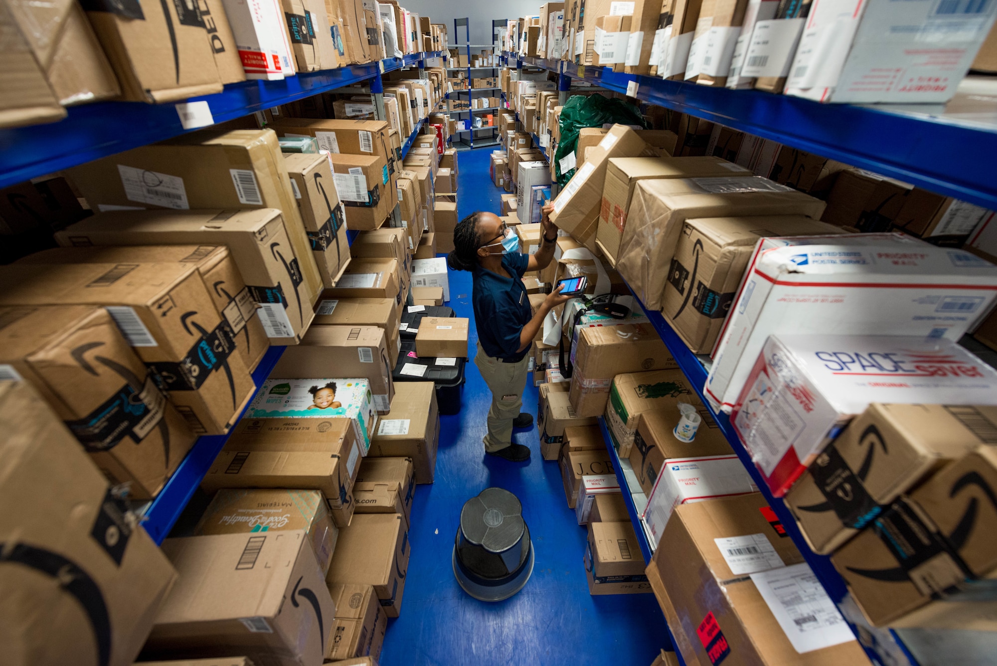 An Airman places a package on a shelving unit in the Northside Post Office at Ramstein Air Base.