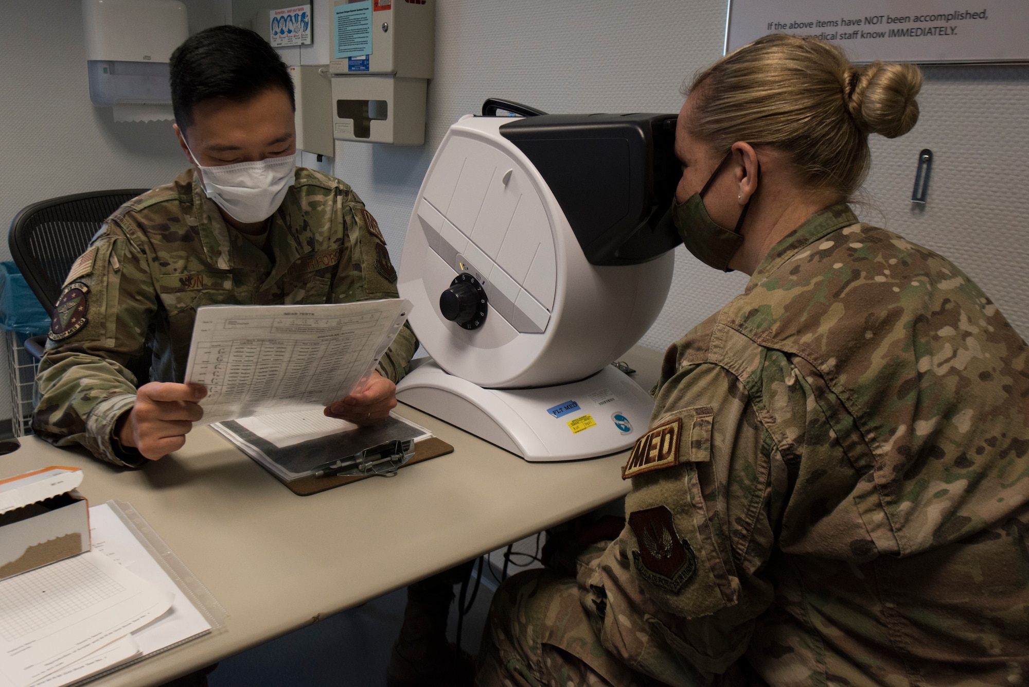 An Airman performs an eye examination.