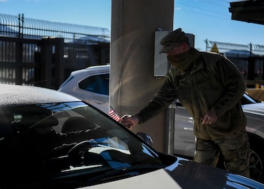 U.S. Air Force Chief Master Sgt. Robert W. Stamper hands out poppies and a flag.