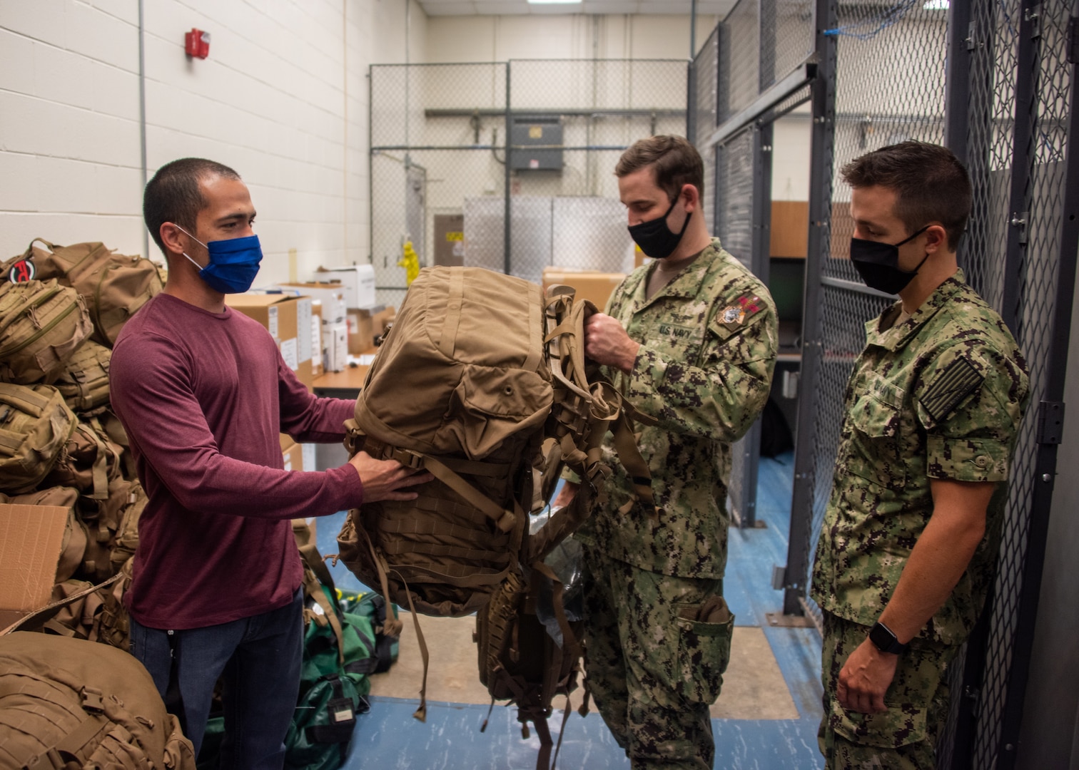 Before the egress testing, Sailors were issued gear to simulate full load out conditions of the Landing Craft Air Cushion. Pictured, Carlos Gonzalez Montanez, issues gear to Hospital Corpsman 1st Class and Hospital Corpsman 3rd Class Kevin Boyaval.