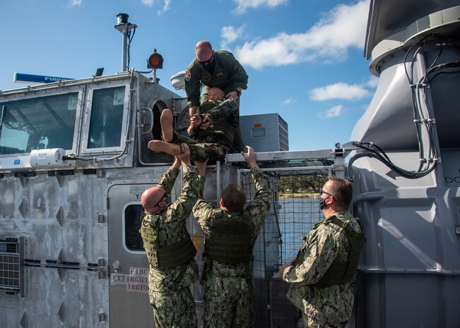 During egress testing, a test dummy was removed from the Landing Craft Air Cushion command area to simulate removing an injured troop through the emergency escape scuttle. Pictured above: Senior Chief Operations Specialist Josh Pearsall. Pictured below: Intelligence Specialist 2nd Class Daniel Boatwright, Lt.j.g. Dale Hussung, and Builder 1st Class Richard Bordelon.