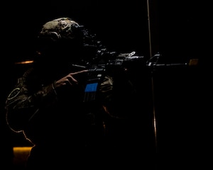 A member of the 633rd Security Forces Squadron enters a room.