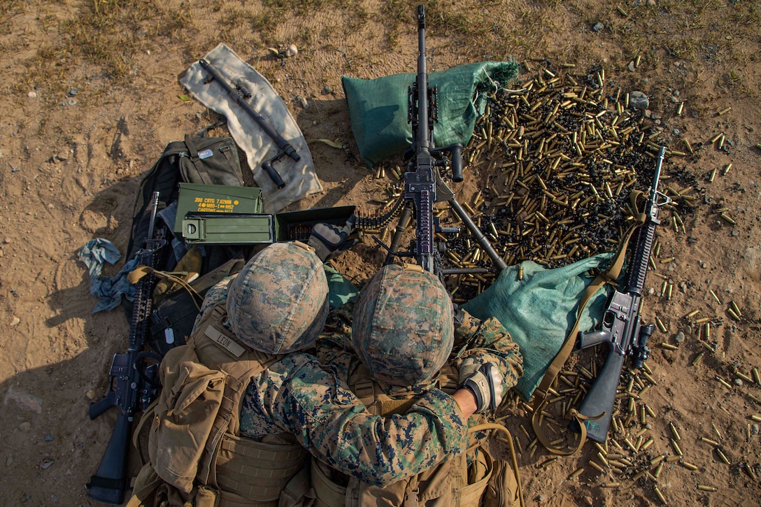 Marines fire a machine gun.